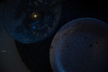 Ceramic plates in a dark room. Romantic mood, date and late dinner. Dark lighting. Top view with copy space