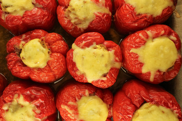 top view of stuffed red sweet pepper with yellow cheese baked in the oven, for food recipes or menu design background