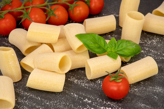 Composition of raw Paccheri Pasta. Variety of traditional Italian pasta in the shape of a tube.