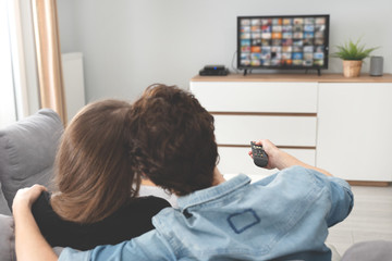 Young couple watching TV on sofa