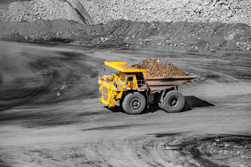 Big yellow mining truck transportation of gold ore. Open pit mine industry