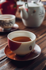 Japanese tea into asian porcelain cup on wood table