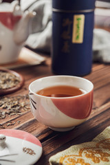 Japanese tea into asian porcelain cup on wood table