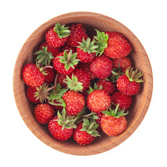heap of wild strawberries in wooden cup isolated on white. top view