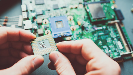 Tech support. Cropped shot of electronic engineer installing CPU. Closeup of motherboard, computer...