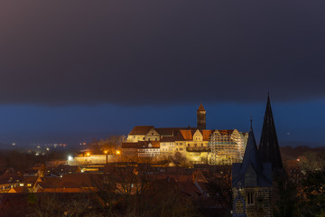 Fototapeta na wymiar Scenic view over the historic old town of Quedlinburg with castle hill in Germany in the evening during blue hour