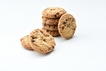 Oatmeal cookies and chocolate chips on light background