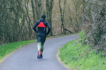 Fototapeta premium Jogger läuft auf einem Waldweg