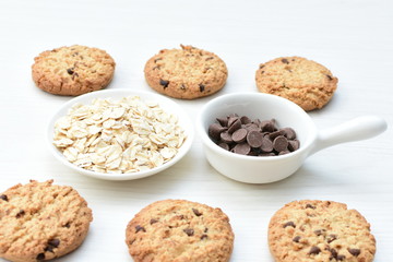 Oatmeal cookies and chocolate chips on light background