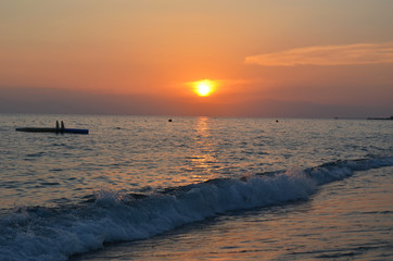 Sea coast. Sun at sunset, evening sky