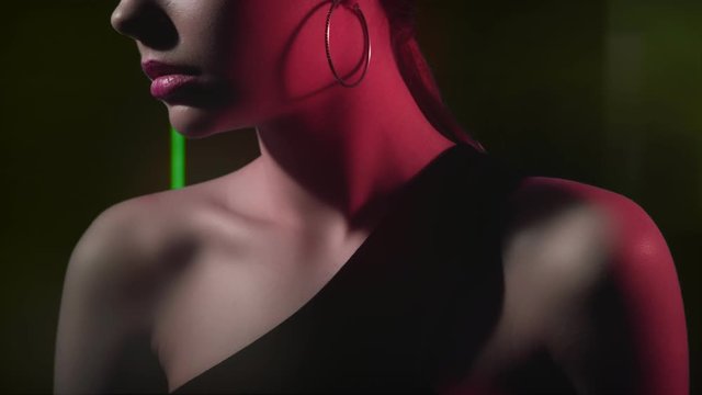 Colored light model. Photo shoot. Fashion girl posing in red green neon glow.