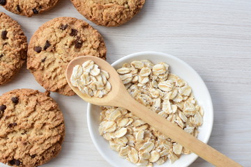 Oatmeal cookies and chocolate chips on light background