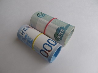 Different Russian rubles banknotes tied with rubber band, on a light background.