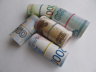 Different Russian rubles banknotes tied with rubber band, on a light background.