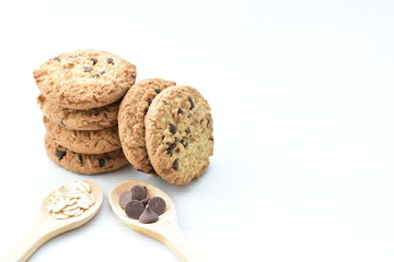 Oatmeal cookies and chocolate chips on light background