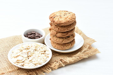 Oatmeal cookies and chocolate chips on cloth background