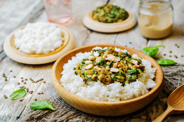 lentils, peanut butter spinach curry with rice on a wood background