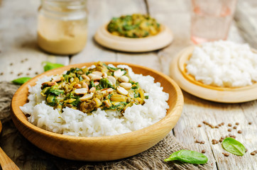 lentils, peanut butter spinach curry with rice on a wood background