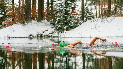 Two female extreme athletes ice swimming in a lake in winter