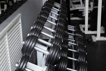 Black dumbbells for fitness classes in the gym.