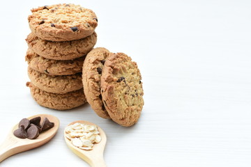 Oatmeal cookies and chocolate chips on light background