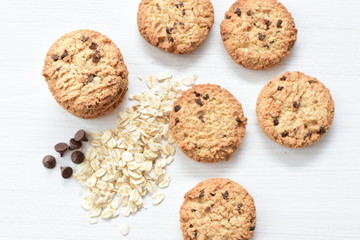 Oatmeal cookies and chocolate chips on light background