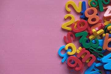 colorful alphabet on a pink background , close up 