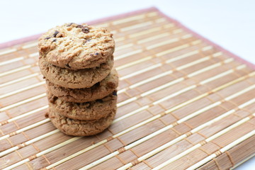 Oatmeal cookies and chocolate chips on light background