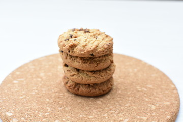 Oatmeal cookies and chocolate chips on light background