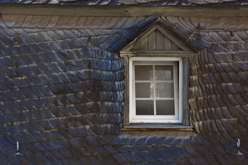 Old dirty dark vintage roof with white window
