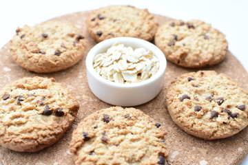 Oatmeal cookies and chocolate chips on light background