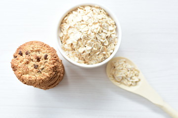 Oatmeal cookies and chocolate chips on light background