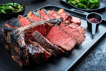 Barbecue dry aged wagyu porterhouse beef steak sliced with large fillet piece as top view on a...
