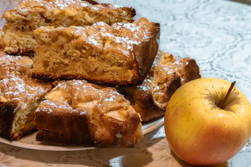 Slices of apple pie with apple lying nearby. Apple pie and apple on the table