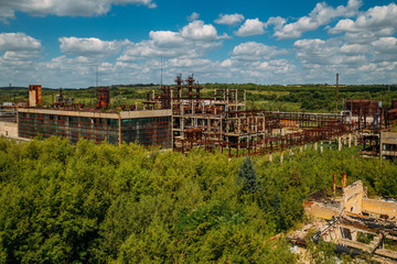 Fototapeta na wymiar Abandoned forgotten ruined chemical plant overgrown by plants and trees, aerial view