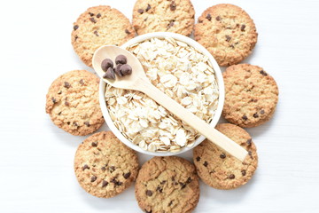 Oatmeal cookies and chocolate chips on light background