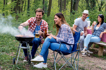 People hanging out having fun while making barbecue in nature