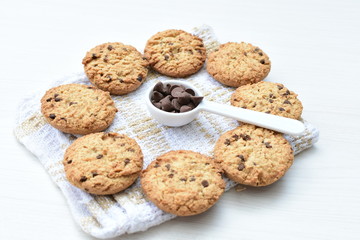 Oatmeal cookies and chocolate chips on light background
