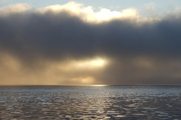 Fog and clouds hovering over the water.