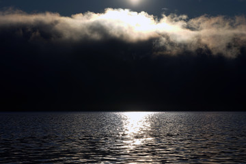 Obraz premium The sun shining over the clouds in the sky.