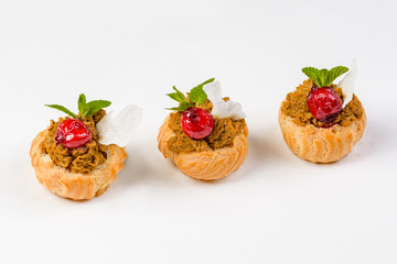 Eclairs with liver pate and cherries on a white background