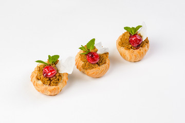 Eclairs with liver pate and cherries on a white background