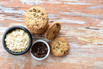 Oatmeal cookies and chocolate chips on light background