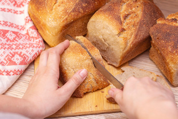 Traditional fresh flavored bread on the table. Food concept. Slicing bread into slices