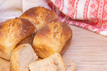 Traditional russian belorussian fresh fragrant bread on the table. Food concept. wooden spoon with flax seeds.