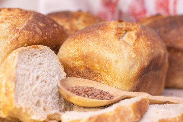 Bakery - golden rustic bread crusts. Fresh aromatic bread on the table. Food concept. wooden spoon with flax seeds.