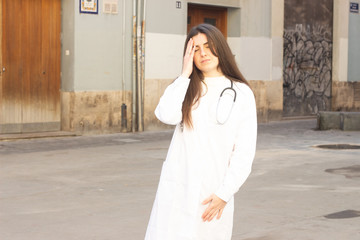 Portrait of tired attractive young woman touching eyes. Pharmacist, beauty therapist, doctor, nurse, scientist, ophthalmologist, beautician, veterinarian, optometrist, in the city, in white coat unifo