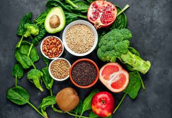 Fototapeta na wymiar Selection of healthy food: fruits, seeds, cereals, superfoods, vegetables, leafy vegetables on a stone background. Healthy food for humans.