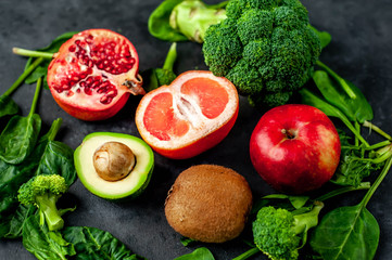 Selection of healthy food:  fruits, seeds, cereals, superfoods, vegetables, leafy vegetables on a stone background. Healthy food for humans.