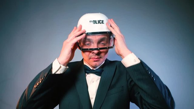 A male policeman takes off and puts a helmet on his head. The concept of an official statement.